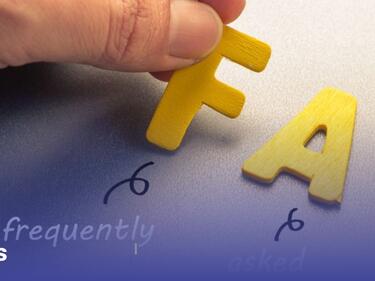 A hand holding the F of FAQ